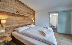 A bed or beds in a room at Glemm Lodge Apartments - JOKER CARD im Sommer inklusive