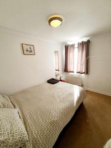 a white bedroom with a bed and a window at Chelmsford Town Centre Apartments With Car Parking in Chelmsford