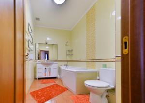 a bathroom with a toilet and a tub and a sink at Apartment На водно-зеленом бульваре in Astana