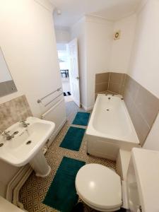 a bathroom with a sink and a toilet and a tub at Chelmsford Town Centre Apartments With Car Parking in Chelmsford +28 photos