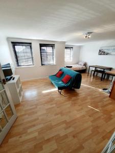 a living room with a blue chair and a table at Chelmsford Town Centre Apartments With Car Parking in Chelmsford