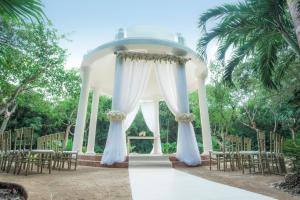 a wedding ceremony at the resort with a gazebo at Iberostar Waves Paraíso del Mar in Puerto Morelos