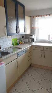 a kitchen with white cabinets and a sink and a window at Ferienwohnung Grüne Oase in Halle an der Saale