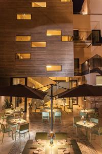 a restaurant with tables and umbrellas in front of a building at Alba Palace Hotel in Favara