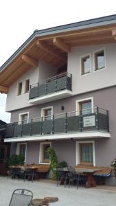 a building with a balcony with tables and chairs at Apartment Hochkönigblick Pilzegg in Embach