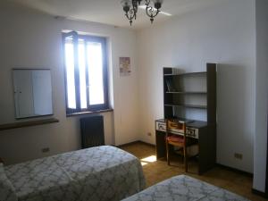 a bedroom with a bed and a desk and a window at CASA IN RIVA AL LAGO in Varenna