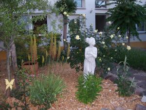 a statue of a woman in a garden at Ferienwohnung Grüne Oase in Halle an der Saale +4 photos