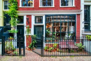 a black fence in front of a house with a bench at Attic Monkeys Lodge in Amsterdam