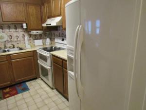 a white refrigerator in a kitchen with wooden cabinets at Sugar Top 2910 condo in Sugar Mountain