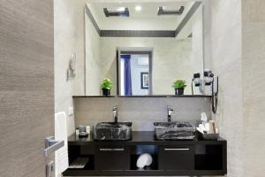 un bagno con due lavandini e un grande specchio di Houses&HousesVEDOROMA a Roma