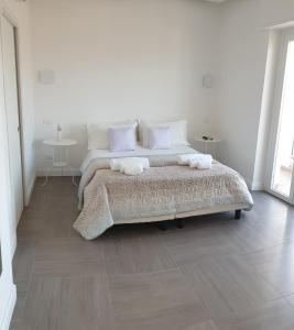 レッジョ・ディ・カラブリアにあるCasual Stay Pentimeleの白いベッドルーム(ベッド1台、タオル2枚付)