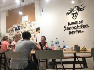 a group of people sitting at a table in a restaurant at Bangkok Sanookdee Hostel in Bangkok