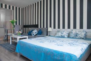 a bedroom with a blue bed and a couch at Sofia Central Hotel Apartments in Sofia