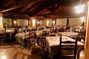 une salle de banquet avec tables et chaises et nappes blanches dans l'établissement Alma Resort, à Castiadas