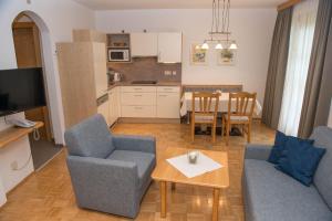 ein Wohnzimmer mit einem Sofa, Stühlen und einem Tisch in der Unterkunft Ferienhaus Franz in Weissbriach