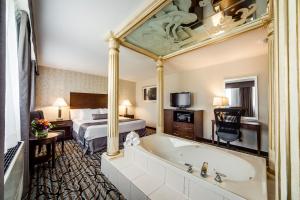 a hotel room with a large tub and a large mirror at Monte Carlo Inn Oakville Suites in Oakville