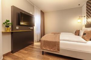 a hotel room with a bed and a television at the niu Mesh in Stuttgart