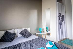 a bedroom with a bed with blue pillows and a window at B&B 1 uit de 100 in Ghent