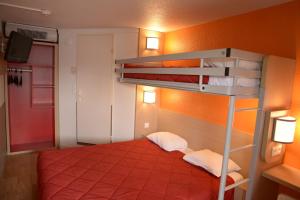 - une chambre avec des lits superposés et un mur orange dans l'établissement Premiere Classe Sete - Balaruc, à Balaruc-le-Vieux
