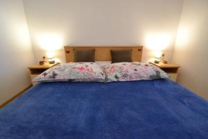 a bedroom with a blue bed with two pillows at Apartmani Antonia Nakić -Stobreč in Split