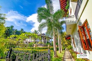 a fence in front of a house with palm trees at Rivora Residence in Kandy