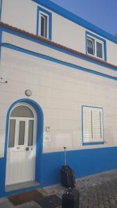 een blauw-wit gebouw met een deur en wat bagage bij Beloved in Porto
