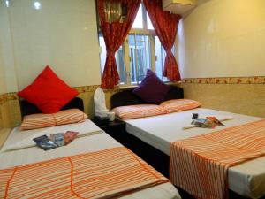 2 letti con cuscini colorati in una camera di New London Hostel a Hong Kong Altre 18 foto