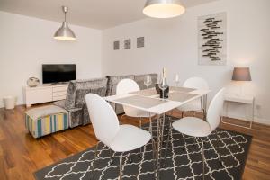 a dining room with a white table and chairs at Two Bedroom Stylish Central Tavira Apartment. in Tavira
