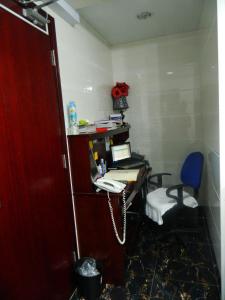 una stanza con una scrivania con un telefono e un computer di New London Hostel a Hong Kong