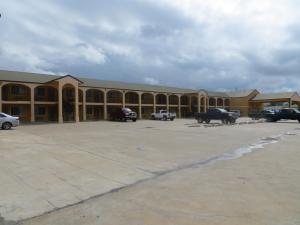 a large building with cars parked in a parking lot at La Grange Executive Inn and Suites in La Grange