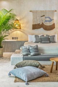 a room with three beds with pillows and a table at Zenses Wellness and Yoga Resort - Adults Only in Tulum