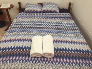 a bed with blue and white sheets and towels on it at Hostal Kin-Beh in Valladolid