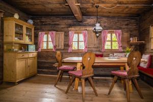 una cocina con mesa y sillas en una cabaña en Tradlhof en Thierbach
