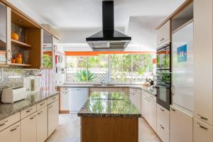 a kitchen with white cabinets and a large window at Casa Laranja Three bedroom Villa in Loulé