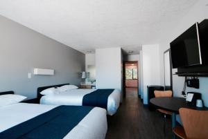 a hotel room with two beds and a table at Motel 6-Saanichton, BC - Victoria Airport in Saanichton