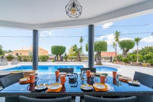 a dining room with a table in front of a pool at Casa Laranja Three bedroom Villa in Loulé