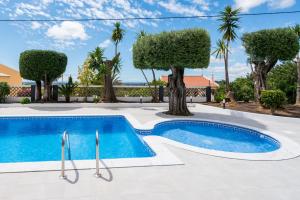 a swimming pool in a villa with palm trees at Casa Laranja Three bedroom Villa in Loulé