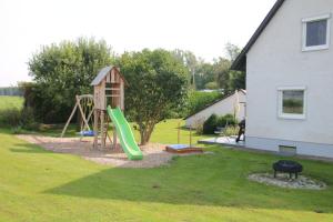 a playground with a slide in a yard at Ferienhaus an der Iller in Aitrach