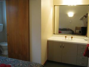 a bathroom with a sink and a mirror at Blue Dolphin Motel in Timaru +42 photos