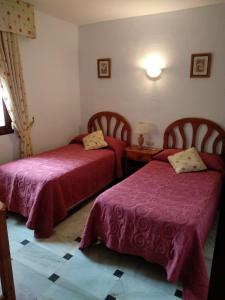 a bedroom with two beds and a table with a lamp at Urb. Lubina Sol in Mijas Costa