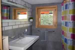 baño con lavabo, ventana y espejo en La Casa Cathomen Brigels - Maiensäss/Berghaus für max. 6 Personen en Brigels