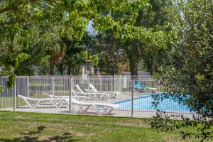 吉索納恰的住宿－阿蘇阿拉度假屋，一个带两把椅子的围栏和一个游泳池