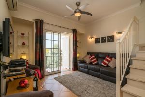 - un salon avec un canapé et un ventilateur de plafond dans l'établissement Two Bedroom Duplex Apartment Vilamoura, à Vilamoura