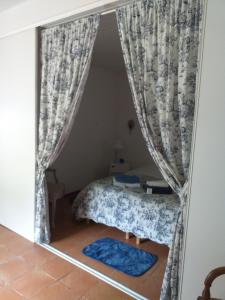 una camera con letto in una stanza con tende di Les Demeures de la Laigne a Allas-Bocage