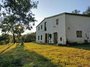 een oud wit gebouw met een picknicktafel ervoor bij Masia Mediterranian Country House Ca l'Isidre Torrent in Sant Cebrià de Vallalta