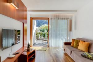 a living room with a couch and a television at Residence & Sportlodges Claudia in Plaus