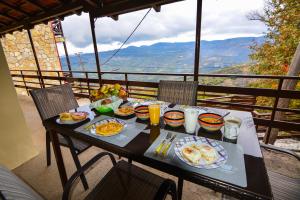 a table with plates of breakfast food on a balcony at The Theater of Dreams in Synikia Mesi Trikalon