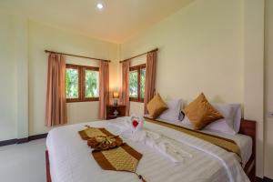 a bedroom with two beds with white sheets at Green Garden House in Ao Nam Mao