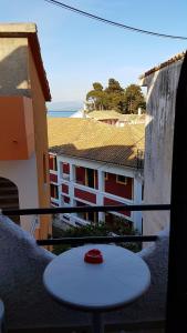 a table on a balcony with a view of a building at Nancy's Rooms 2 in Gouvia