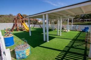 una zona de juegos con un parque infantil con tobogán en Le Dune Resort en Menfi